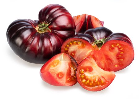 Tomates maduros negros o morados y rodajas de tomate aisladas sobre fondo blanco. 