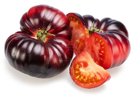 Tomates maduros negros o morados y rodajas de tomate aisladas sobre fondo blanco. 