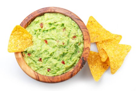 Guacamole sauce and tortilla chips, popular Mexican food  top view on white background. 