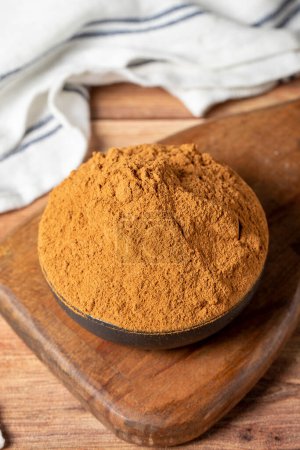 Téléchargez les photos : Powdered cinnamon spice. Ground cinnamon in a bowl on a wooden background. Dry spice concept. close up - en image libre de droit