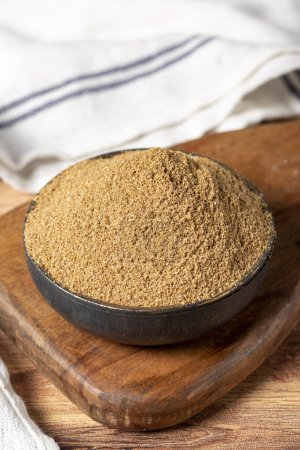 Foto de Powdered coriander spice. Coriander powder or dhaniya powder on wooden background. Dry spice concept. close up - Imagen libre de derechos