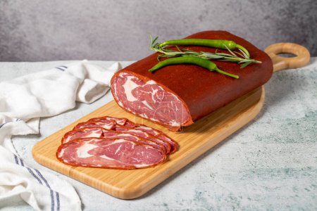 Foto de Beef ribeye pastrami. Dried turkish bacon slice on wooden Cutting Board. Traditional Turkish delicacies. Local name cemenli pastirma - Imagen libre de derechos