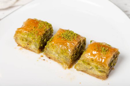 Photo for Baklava with pistachio on a wood background. Traditional Turkish baklava. Local name ankara sarmasi. Close up - Royalty Free Image