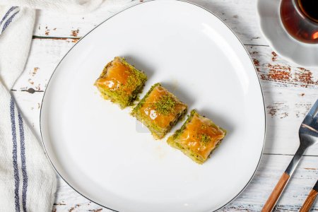 Photo for Baklava with pistachio on a wood background. Traditional Turkish baklava. Local name ankara sarmasi. Top view - Royalty Free Image