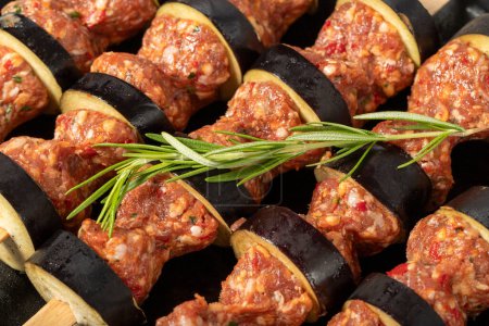 Photo for Eggplant kebab. Close-up of aubergine shish kebab with raw minced meat. Food background.Turkish cuisine delicacies. Local name patlican kebabi - Royalty Free Image