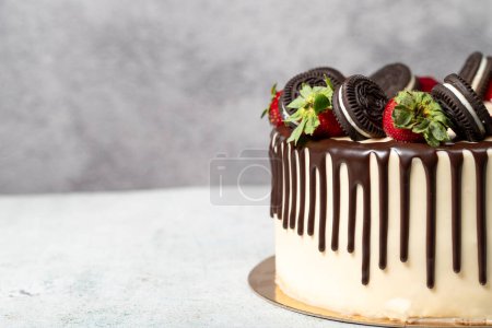 Pastel de chocolate. Chocolate líquido y pastel de cumpleaños de fresa sobre fondo gris