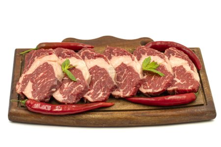 Téléchargez les photos : Viande entrecote de veau isolée sur fond blanc. Bifteck de côtes de boeuf cru aux herbes et épices - en image libre de droit