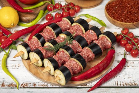 Photo for Eggplant kebab on wood background. Raw shish eggplant kebab with herbs and spices - Royalty Free Image