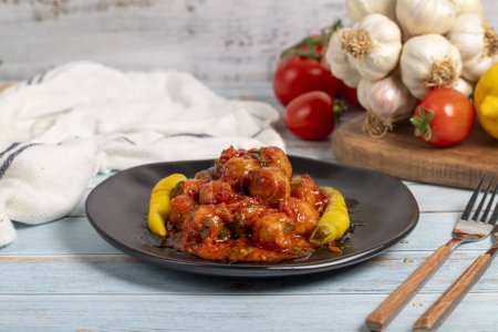 Aleppo meatballs. Appetizer dishes. Small meatballs with tomato paste on a blue wooden background