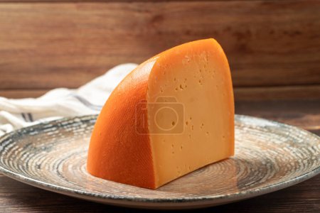 Mimolette cheese. Dairy products. Slices of Mimolette cheese on a plate