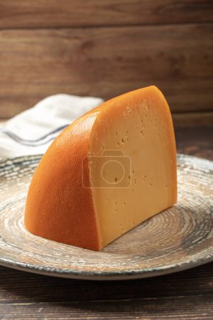 Mimolette cheese. Dairy products. Slices of Mimolette cheese on a plate. Close up