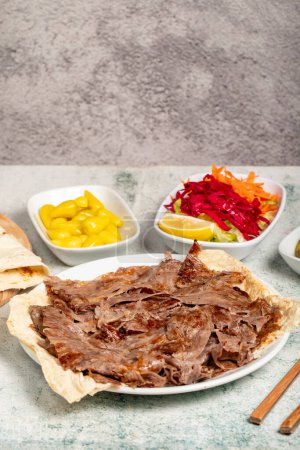 Meat doner kebab. Turkish and Middle Eastern cuisine flavors. Doner kebab on stone floor. Local name tabakta et doner