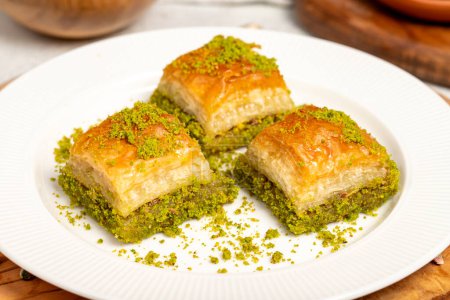 Baklava mit Pistazien auf einem hölzernen Hintergrund. Türkische Spezialitäten. Ramadan-Dessert. lokaler Name kuru baklava