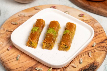 Kadayif with pistachios on a wooden background. Turkish cuisine delicacies. Ramadan Dessert. local name burma kadayif