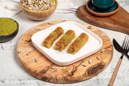 Kadayif mit Pistazien auf einem hölzernen Hintergrund. Türkische Spezialitäten. Ramadan-Dessert. lokaler Name burma kadayif