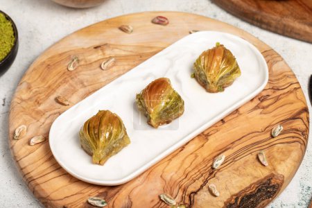 Mussel baklava with pistachios on a wooden background. Turkish cuisine delicacies. Ramadan Dessert. local name midye baklava