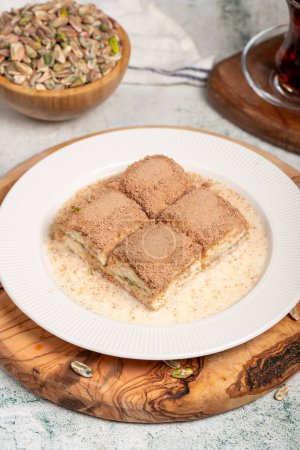 Cold baklava with pistachios on a wooden background. Turkish cuisine delicacies. Ramadan Dessert. local name soguk baklava
