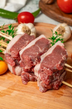Lamb sirloin. Lamb sirloin meat skewered on a wooden serving board