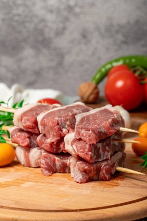 Lamb sirloin. Lamb sirloin meat skewered on a wooden serving board. Close up