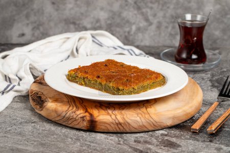 Kadayif dessert with syrup. Traditional Turkish cuisine desserts. Kadayif with pistachios on a wooden serving board
