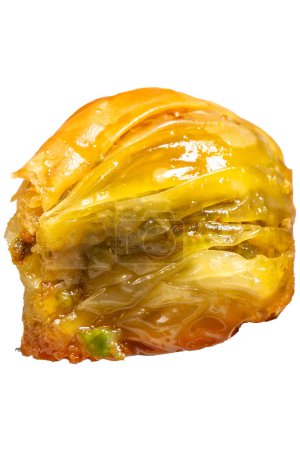 Muschelbaklava mit Pistazien auf weißem Hintergrund. Türkische Spezialitäten. Ramadan-Dessert. Er hält eine Scheibe Baklava auf der Gabel