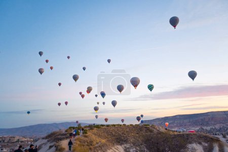 Téléchargez les photos : Vue imprenable sur de nombreux ballons colorés volant dans les airs pendant le lever du soleil calme. La Cappadoce - l'un des endroits les plus populaires pour les vols en montgolfière dans le monde,. Photo de haute qualité - en image libre de droit