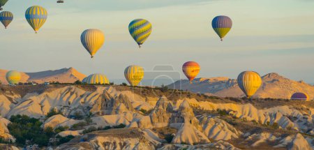 Téléchargez les photos : Aventure estivale. en Cappadoce, Turquie. Vue panoramique de drones de nombreux ballons colorés survolant d'anciennes grottes et formations rocheuses. Voyager en Asie de l'Ouest. Photo de haute qualité - en image libre de droit