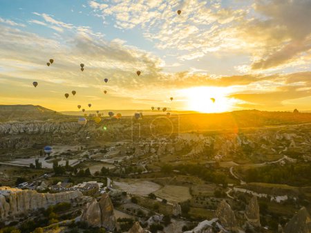 Téléchargez les photos : Concept de ballon. Superbe lever de soleil sur la ville de Cappadoce. Ciel turc illuminé rempli de braves voyageurs dans des montgolfières et des paniers en osier. Photo de haute qualité - en image libre de droit