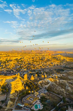 Téléchargez les photos : Étonnantes formations rocheuses en Cappadoce, Turquie. Montgolfières à air chaud avec gondoles ou paniers en osier loin dans le paysage de fond. Perspective verticale du drone. Photo de haute qualité - en image libre de droit