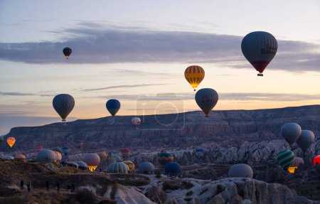 Téléchargez les photos : Cappadoce - ville turque célèbre pour organiser des vols de montgolfières au lever du soleil tôt le matin. Ciel légèrement nuageux. Concept touristique. Photo de haute qualité - en image libre de droit