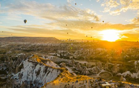 Téléchargez les photos : Aventure estivale. Soleil levant illuminant un beau ciel plein de montgolfières volant au-dessus de la ville de Cappadoce, Turquie. Photo de haute qualité - en image libre de droit