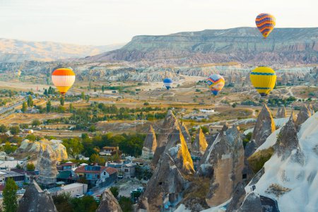 Téléchargez les photos : 10.11.2022 Cappadoce, Turquie. Plusieurs montgolfières aux couleurs vives survolant la paisible ville turque de Cappadoce. Vue aérienne de paysages intéressants et de grottes célèbres. Photo de haute qualité - en image libre de droit
