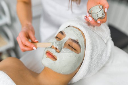 Photo for Professional putting facial mask for her client at the beauty center, closeup side view beauty treatment. High quality photo - Royalty Free Image