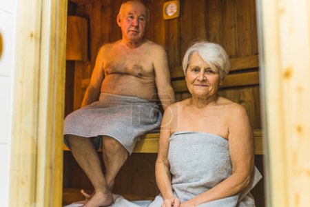 Photo for Caucasian grandmother and grandfather in a wooden sauna. Healthcare and relaxation concept. Elderly female pensioner looking at camera. High quality photo - Royalty Free Image