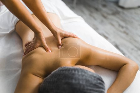 Foto de Medium shot of two hands massaging a womans back. Spa concept. Beauty concept. High quality photo - Imagen libre de derechos