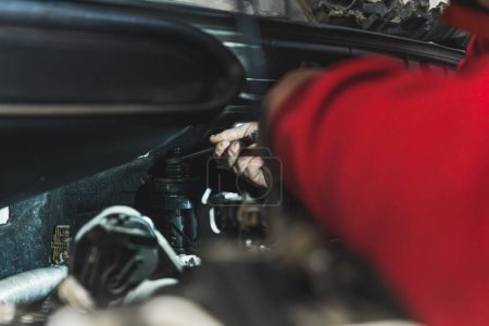 Téléchargez les photos : Mechanic removes a stuck injector in a diesel engine with the press in an auto repair shop. High-quality photo - en image libre de droit