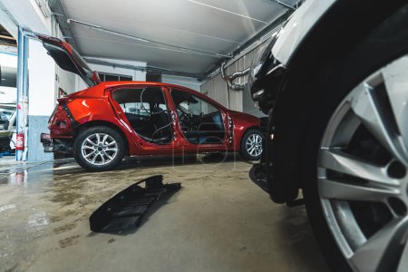 Foto de Red car body at repair shop, indoor background shot. High quality photo - Imagen libre de derechos