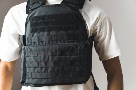 Black bullet proof vest on man body. No face. High quality photo