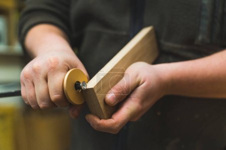 Foto de Manos de cerca de un carpintero usando un medidor para marcar líneas en un bloque de madera. Foto de alta calidad - Imagen libre de derechos