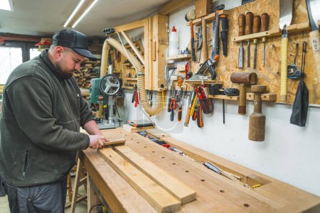Carpintero quitar virutas de madera de tablones usando cepillo en un estudio de carpintería. Foto de alta calidad