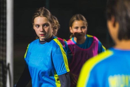 Foto de Niñas en edad escolar jugando al fútbol por la noche en un estadio, niñas practican, tiro medio. Foto de alta calidad - Imagen libre de derechos