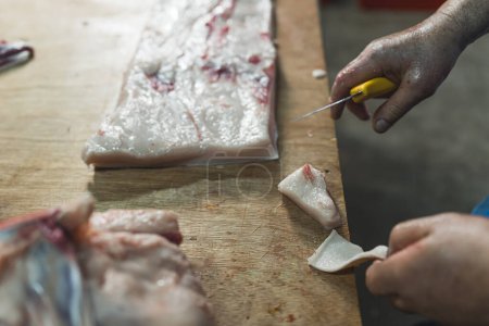Photo for Close up of butchers hands slicing raw steak on butchers block. High quality photo - Royalty Free Image