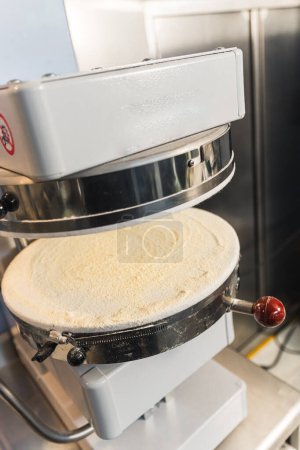 Foto de Vertical closeup shot of a modern machine pressing the dough. High quality photo - Imagen libre de derechos