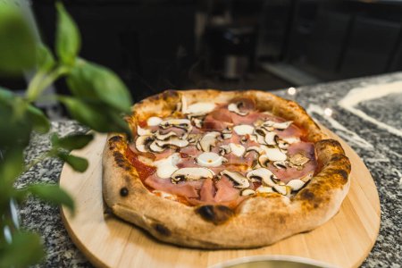 gros plan de pizza aux champignons et bacon sur une planche en bois, cuisine italienne. Photo de haute qualité