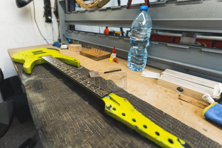 reperation of the yellow electric guitar at the workshop, smoothening frets sharp ends. High quality photo