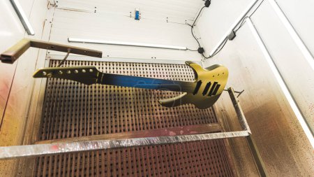 nouvellement coloré guitare bronze accroché dans l'atelier pour obtenir sec, usine de guitare. Photo de haute qualité