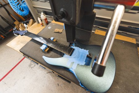 concept de production de guitare, fabrication d'une nouvelle guitare à l'usine, frets machine d'ajout. Photo de haute qualité