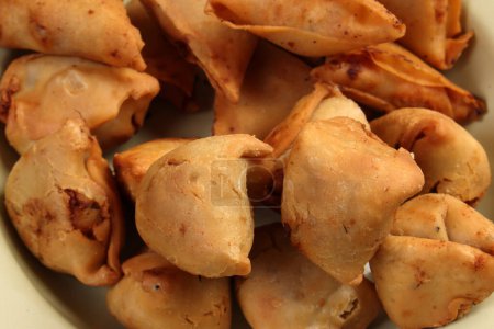 Foto de Samosa singara frita rellenas de carne picada de papa snacks de benglai vegetales en placa de metal de estaño de esmalte - Imagen libre de derechos