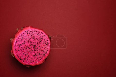 Téléchargez les photos : Cactus exotique rouge rubis fruit du dragon coupe entière moitié sur fond rouge - en image libre de droit
