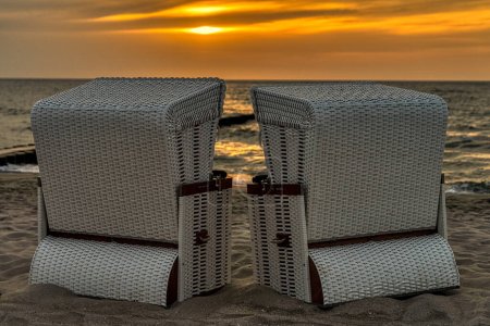 Liegestühle mit Blick auf den Sonnenuntergang am Strand in Ahrenshoop, Mecklenburg-Vorpommern, Deutschland